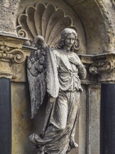 Verwitterter Engel an der Friedhofsmauer der Familie Rost