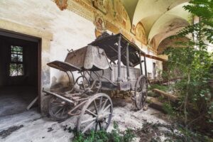 Eine uralte hölzerne Leichenkutsche liegt vergessen im Innenhof eines alten Klosters in Mittelitalien